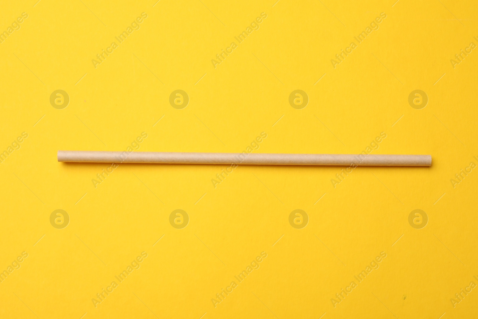 Photo of Bamboo drinking straw on yellow background, top view