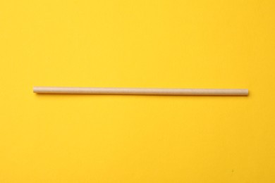 Photo of Bamboo drinking straw on yellow background, top view