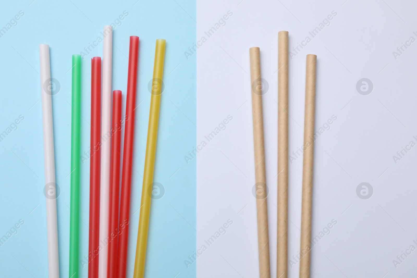 Photo of Plastic and bamboo drinking straws on color background, flat lay