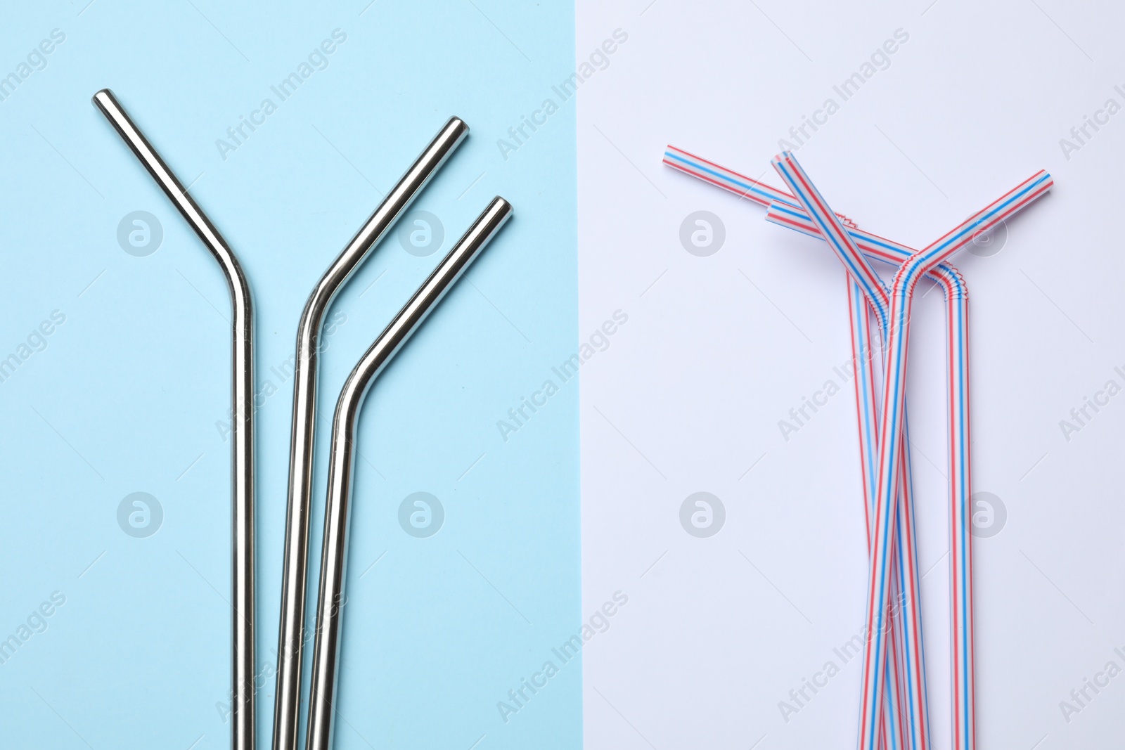 Photo of Metal and plastic drinking straws on color background, flat lay