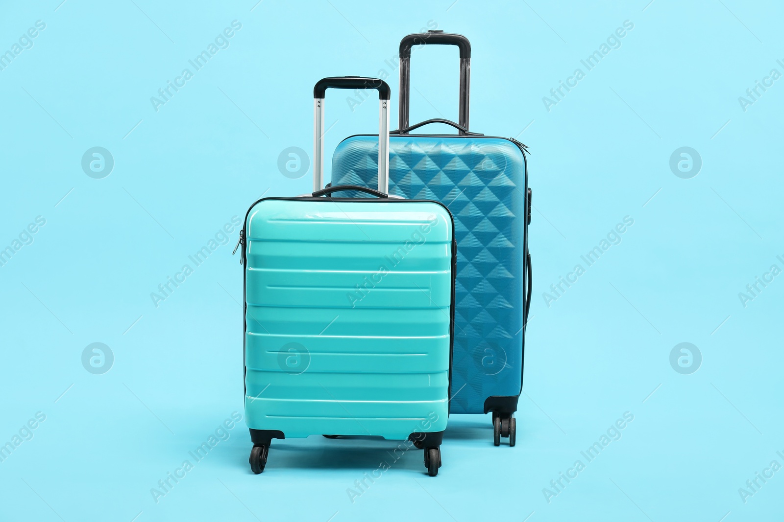 Photo of Different bright suitcases on light blue background