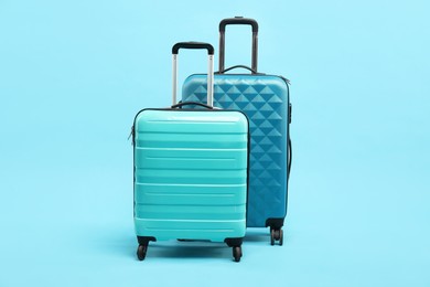 Photo of Different bright suitcases on light blue background