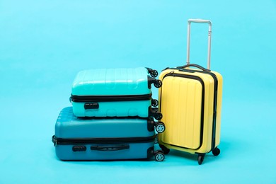 Photo of Different bright suitcases on light blue background