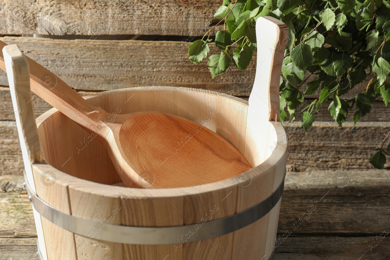 Photo of Sauna equipment. Bucket and ladle on wooden surface, closeup