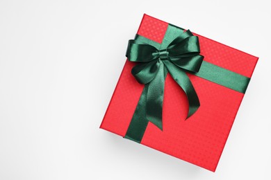 Photo of Gift box with green bow on light grey background, top view. Space for text