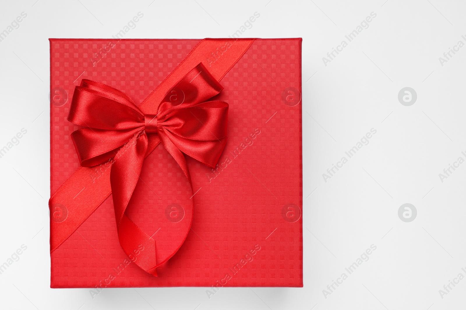 Photo of Gift box with bow on light grey background, top view. Space for text