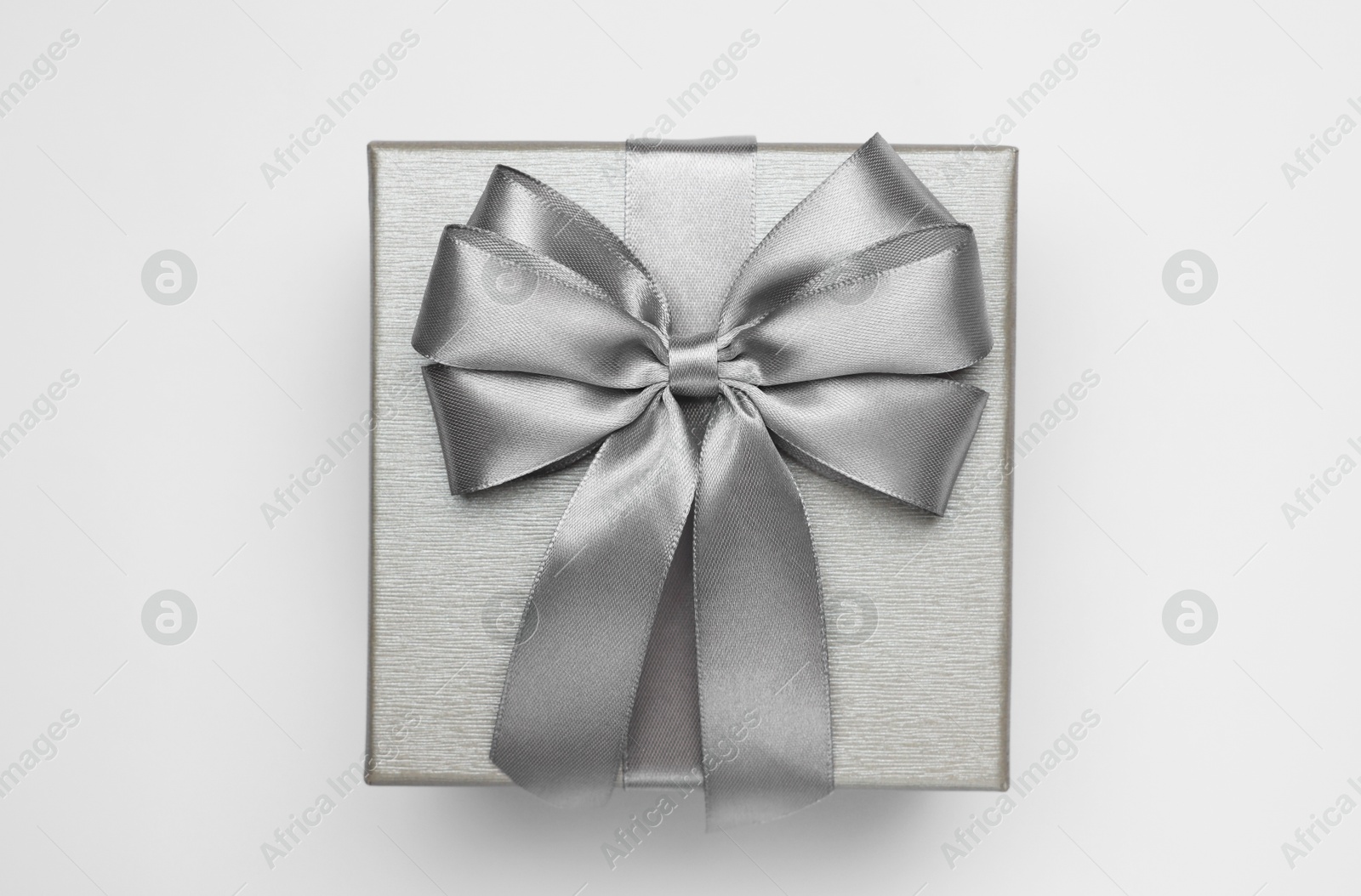 Photo of Gift box with bow on light grey background, top view