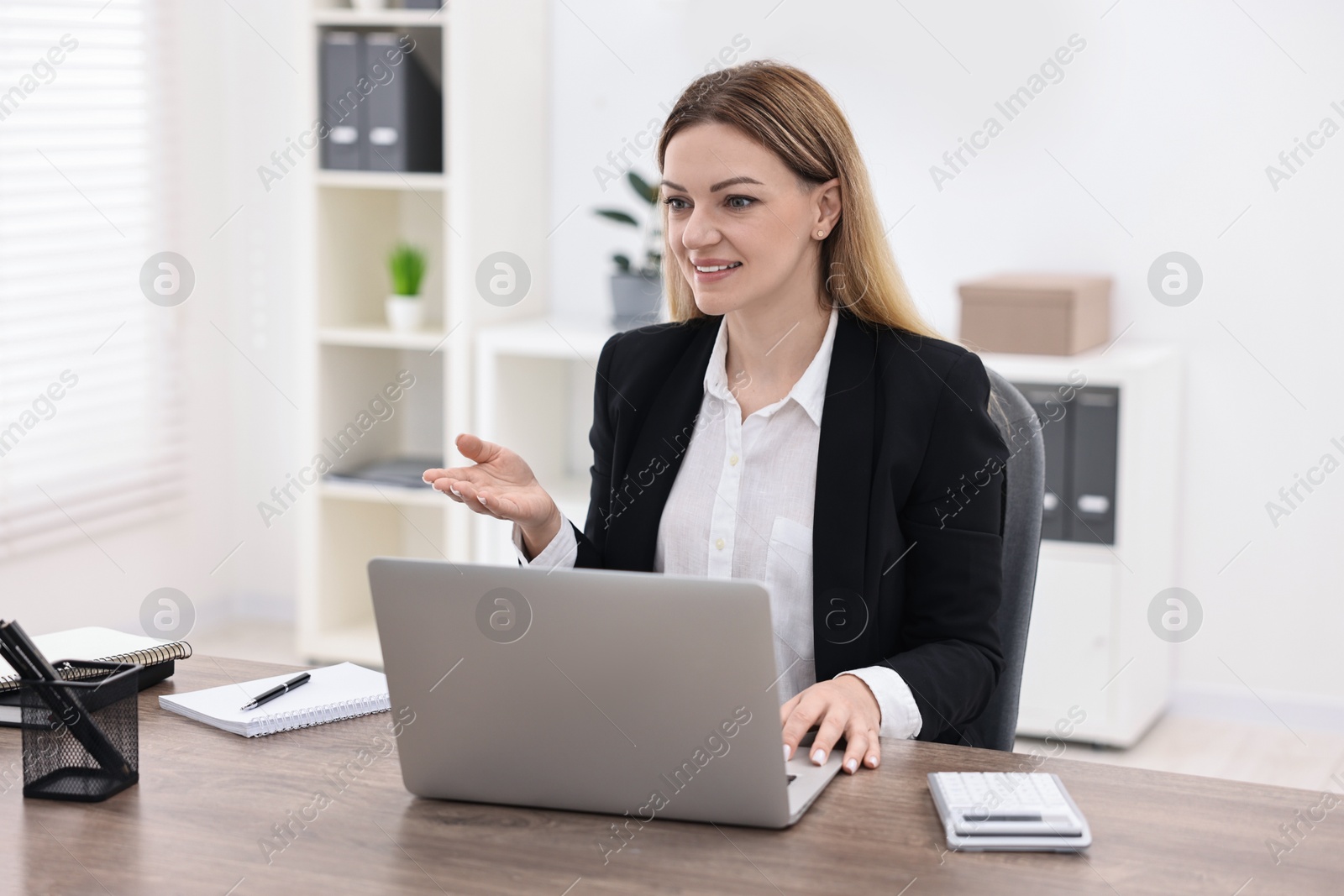 Photo of Banker with laptop working at wooden table in office