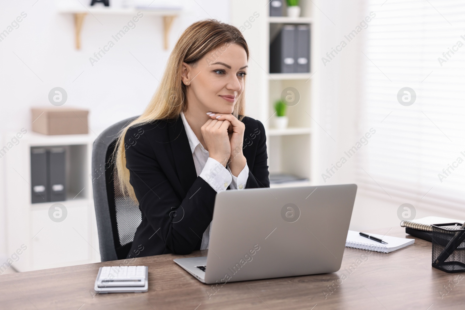 Photo of Banker with laptop working at wooden table in office