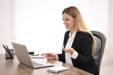 Photo of Banker with laptop working at table in office