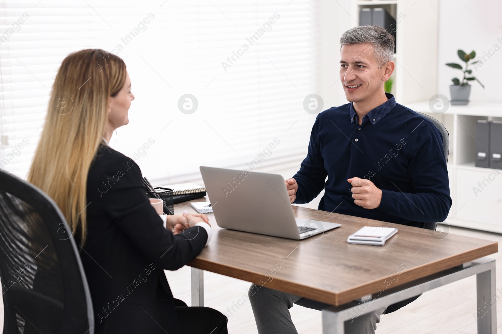 Photo of Banker working with client at table in office