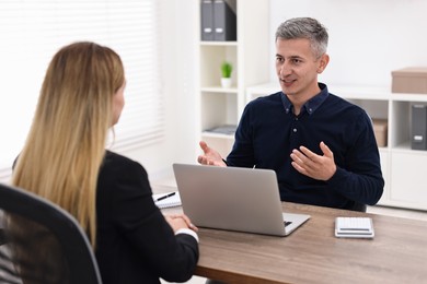 Banker working with client at wooden table in office