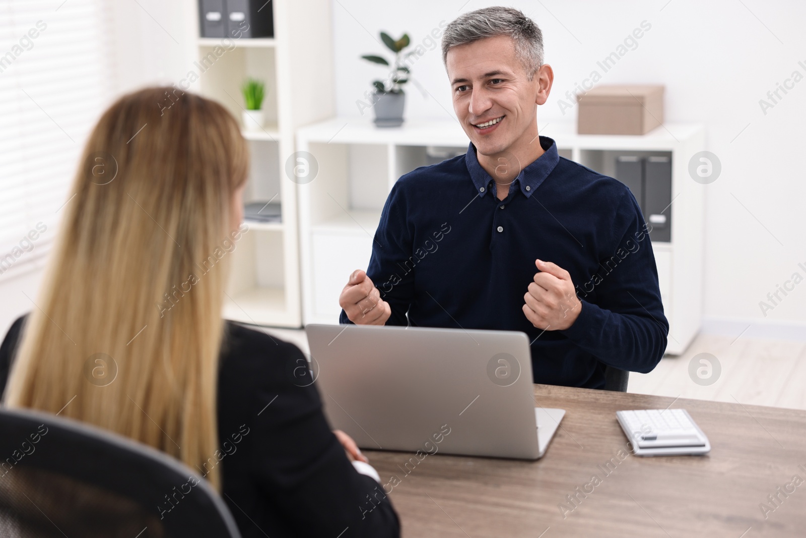 Photo of Banker working with client at wooden table in office