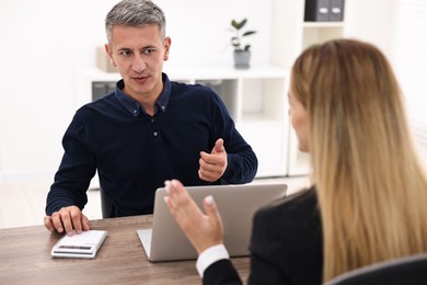 Banker working with client at wooden table in office