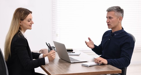 Photo of Banker working with client at table in office