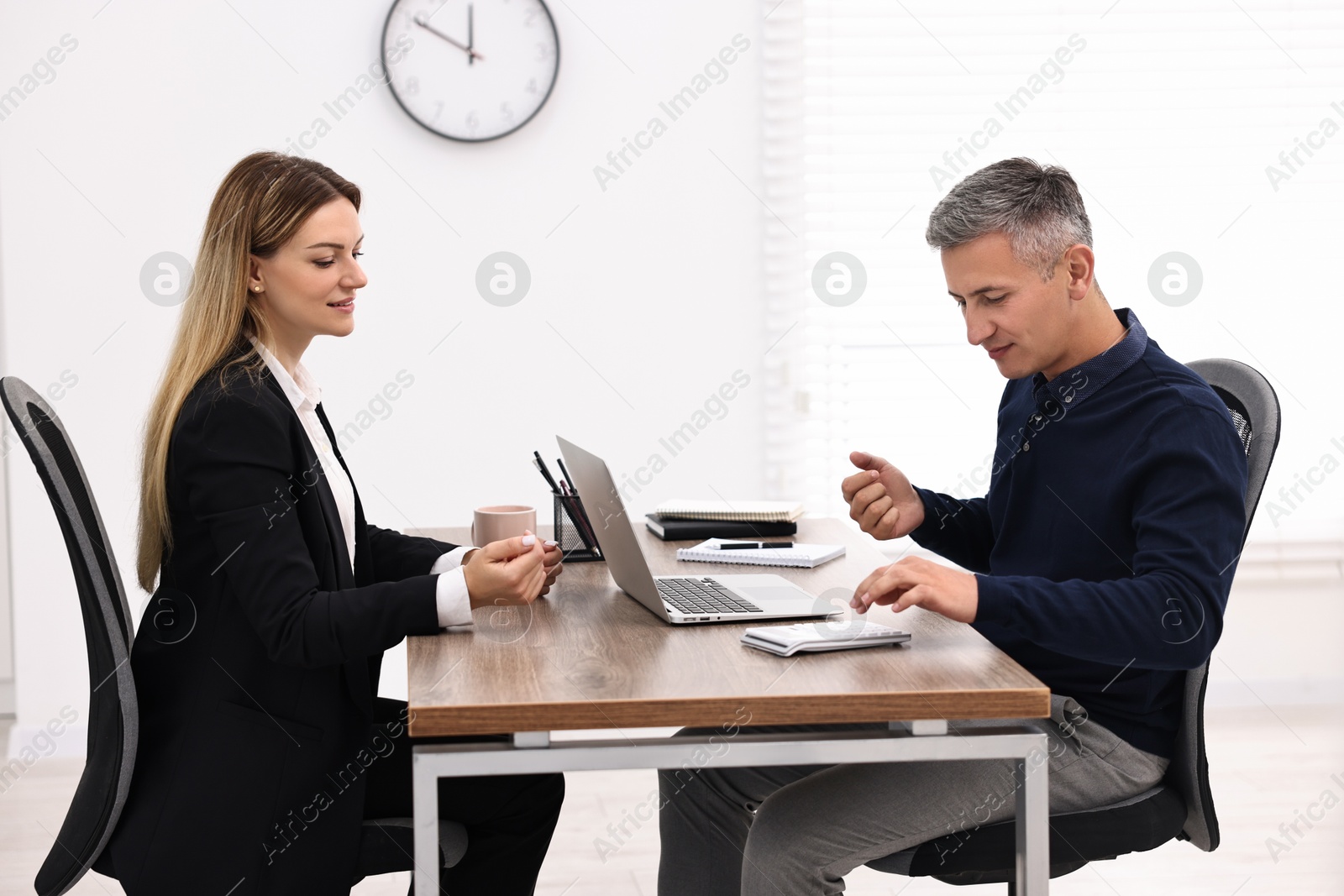 Photo of Banker working with client at table in office