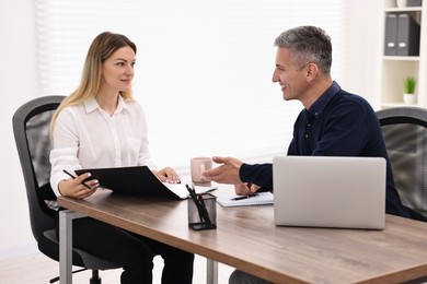 Photo of Banker working with client at table in office