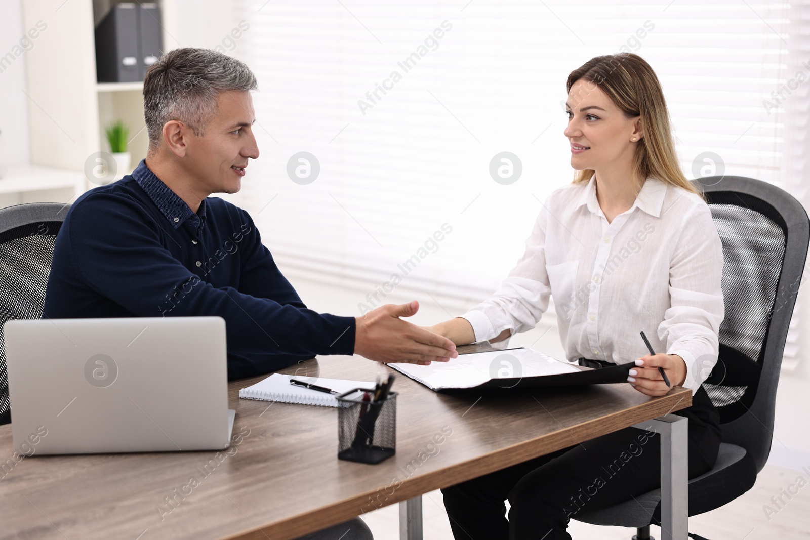 Photo of Banker working with client at table in office