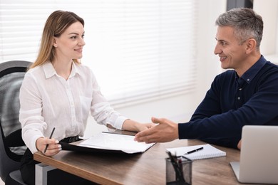 Banker working with client at table in office