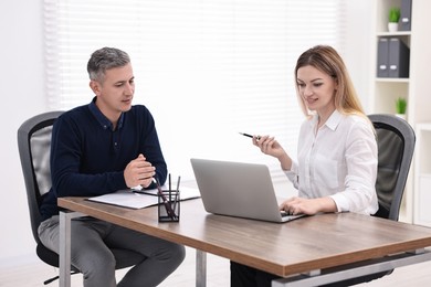 Banker working with client at wooden table in office