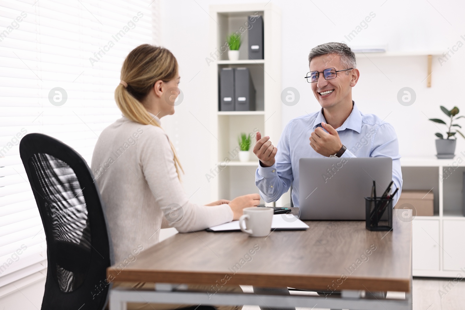 Photo of Banker working with client at table in office