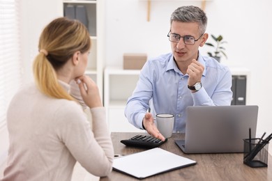 Banker working with client at table in office