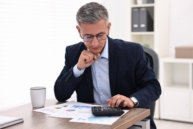 Banker working at wooden table in office