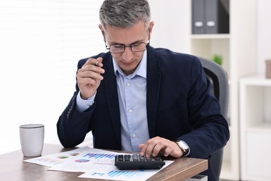 Photo of Banker working at wooden table in office