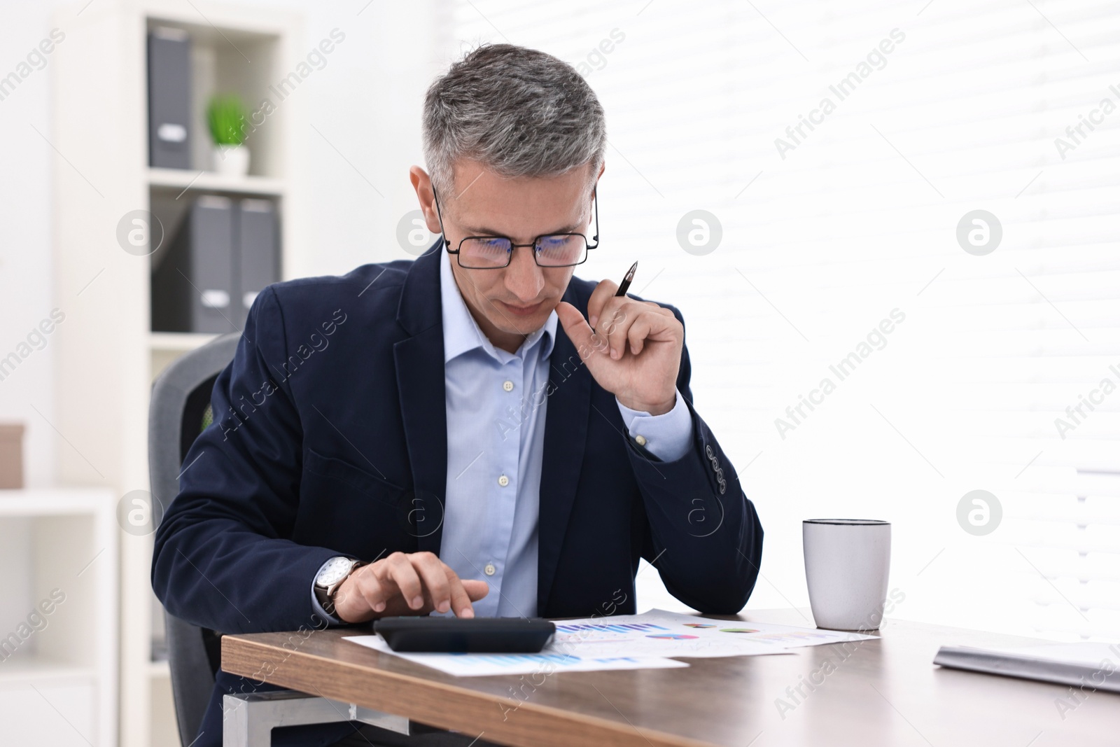 Photo of Banker working at wooden table in office