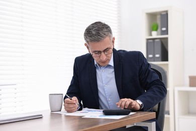 Photo of Banker working at wooden table in office