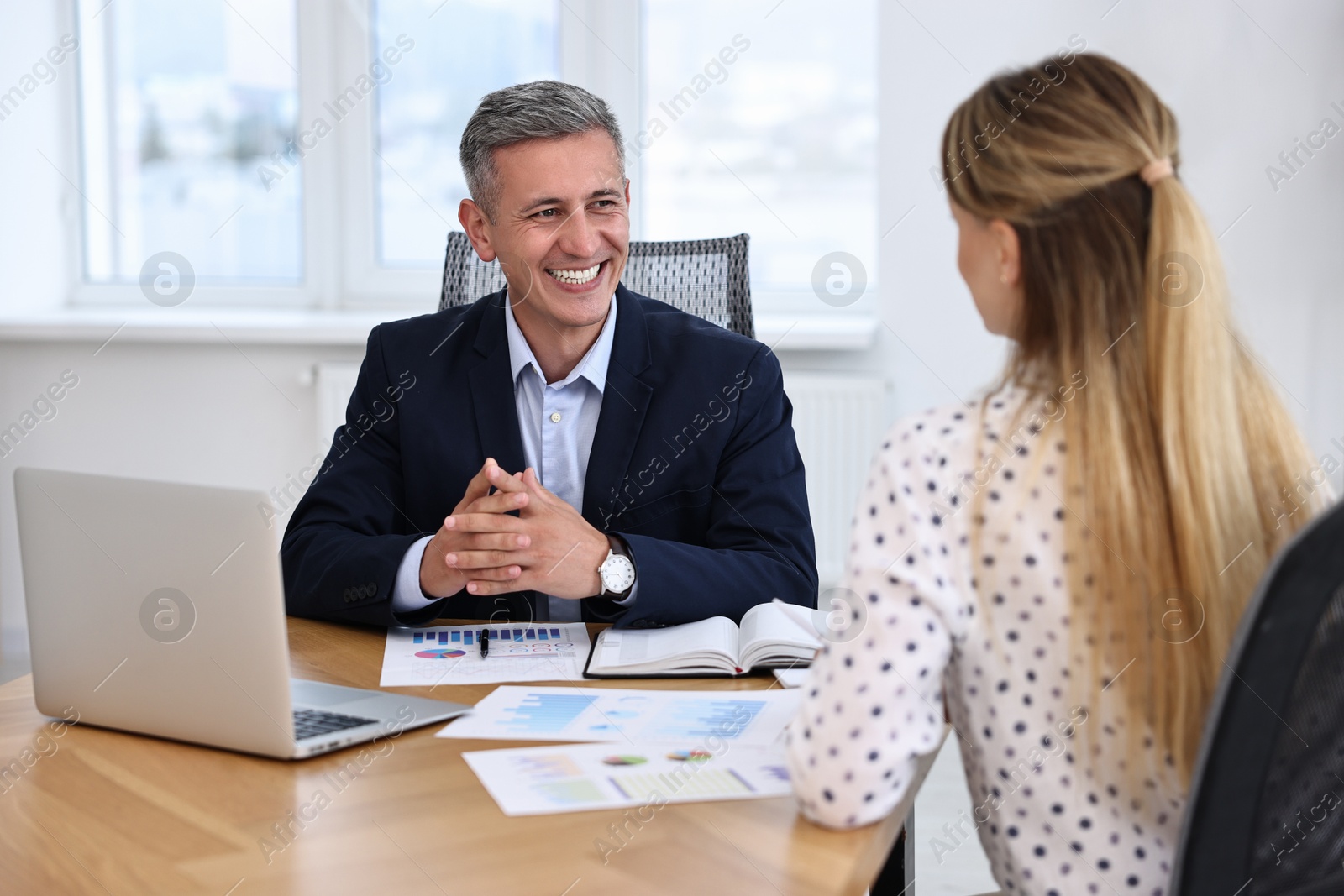 Photo of Banker working with client at table in office