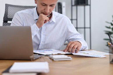 Banker working at wooden table in office