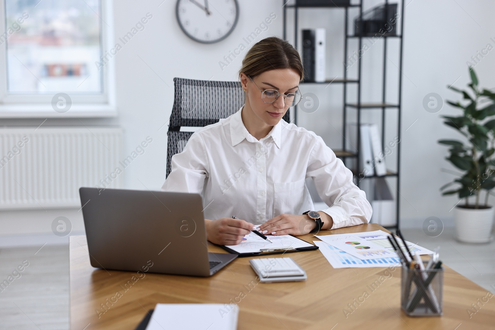 Photo of Banker working at wooden table in office