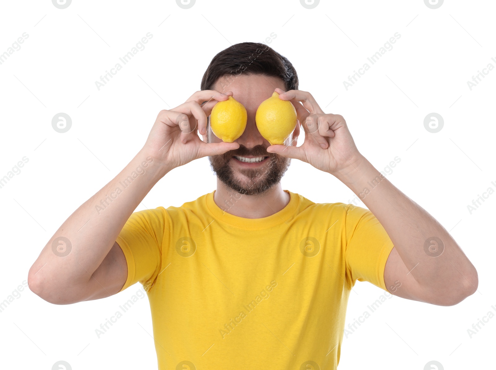 Photo of Happy man covering eyes with lemons on white background