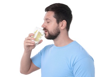 Photo of Handsome man drinking water with lemon on white background