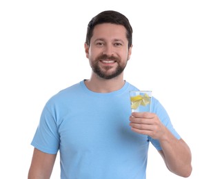 Happy man holding glass of water with lemon on white background