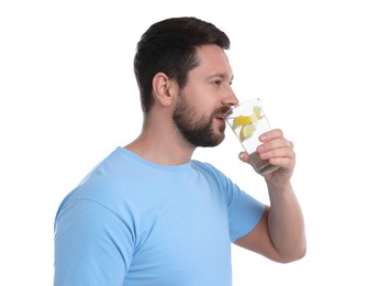 Handsome man drinking water with lemon on white background