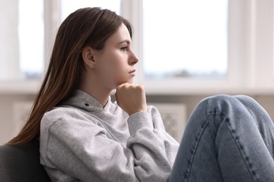 Loneliness concept. Sad teenage girl on sofa at home