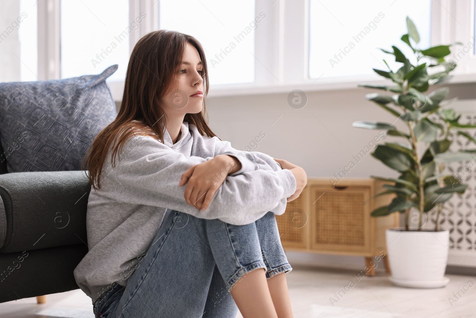 Photo of Loneliness concept. Sad teenage girl on floor at home