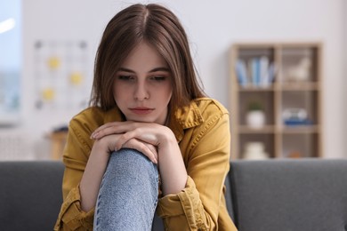 Loneliness concept. Sad teenage girl on sofa at home