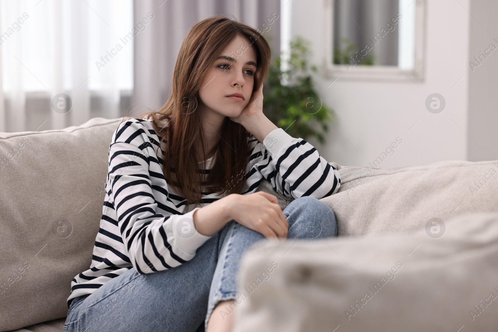 Photo of Loneliness concept. Sad teenage girl on sofa at home