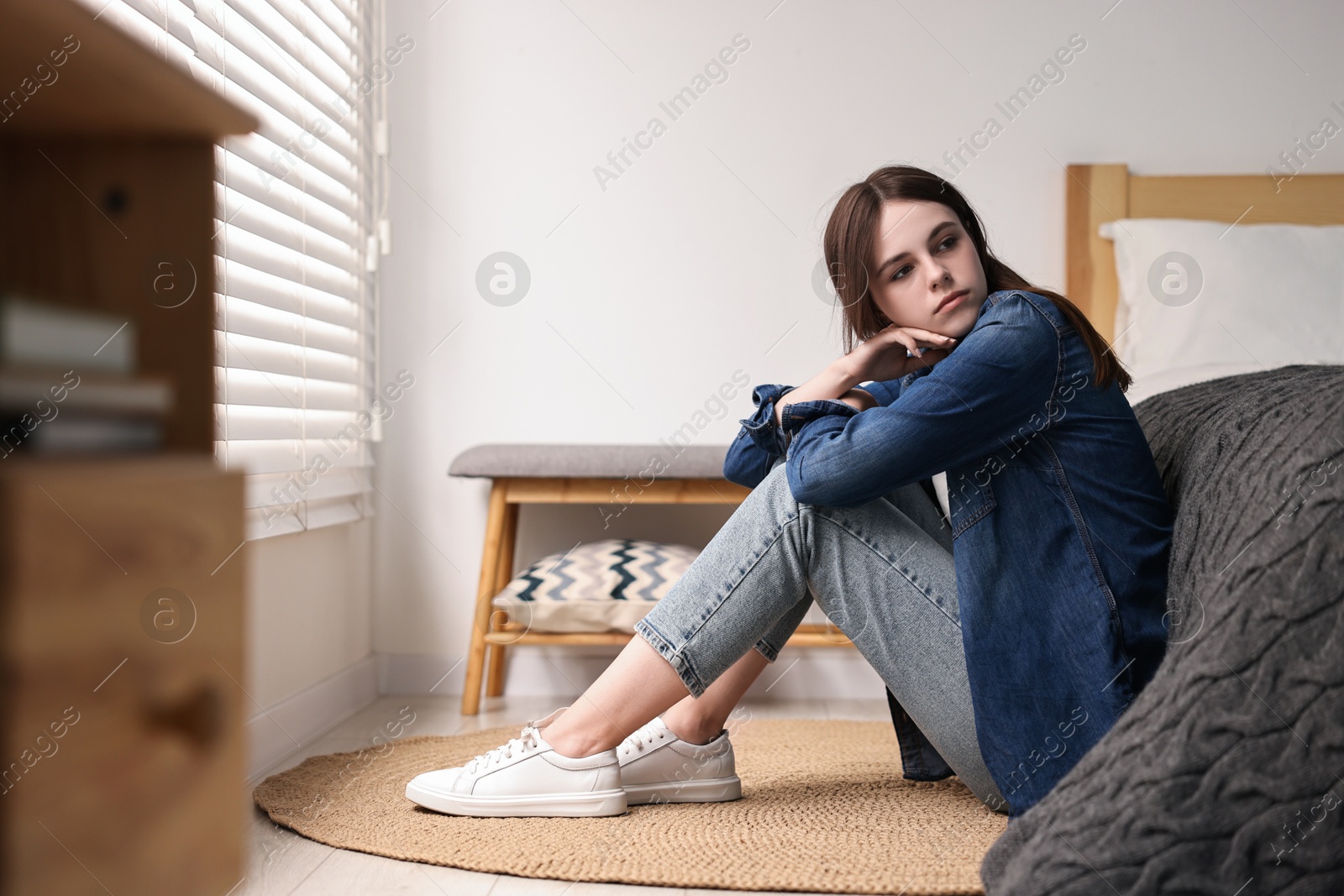 Photo of Loneliness concept. Sad teenage girl on floor at home