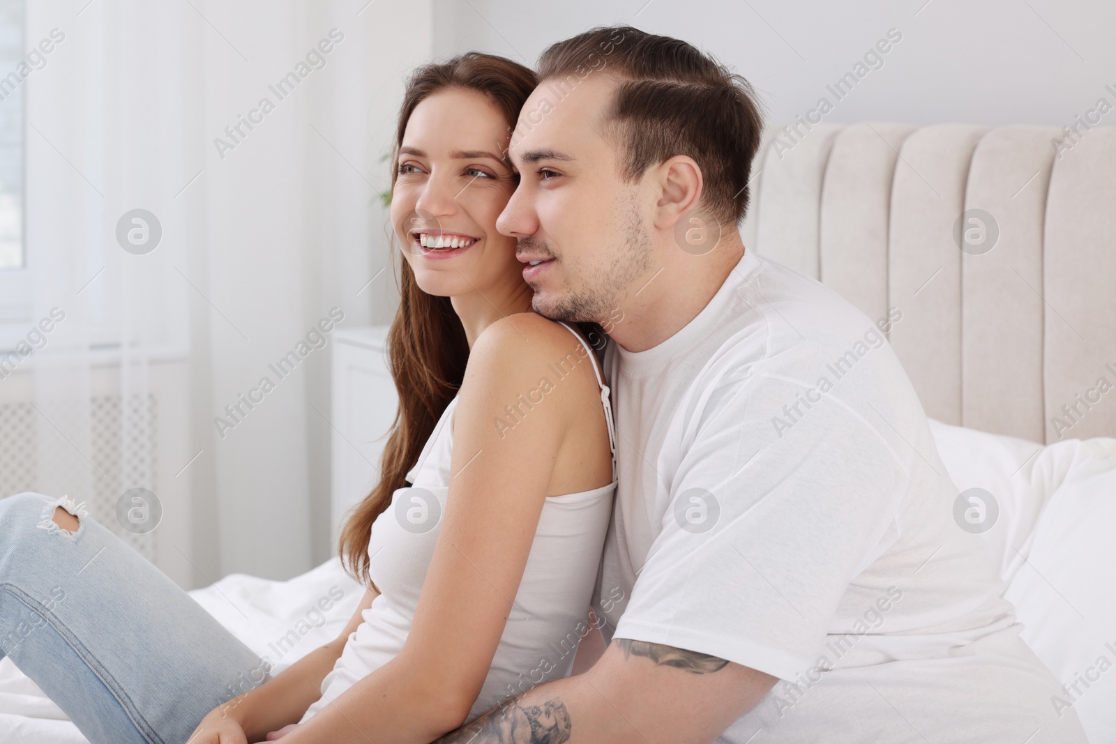 Photo of Happy couple spending time together on bed at home