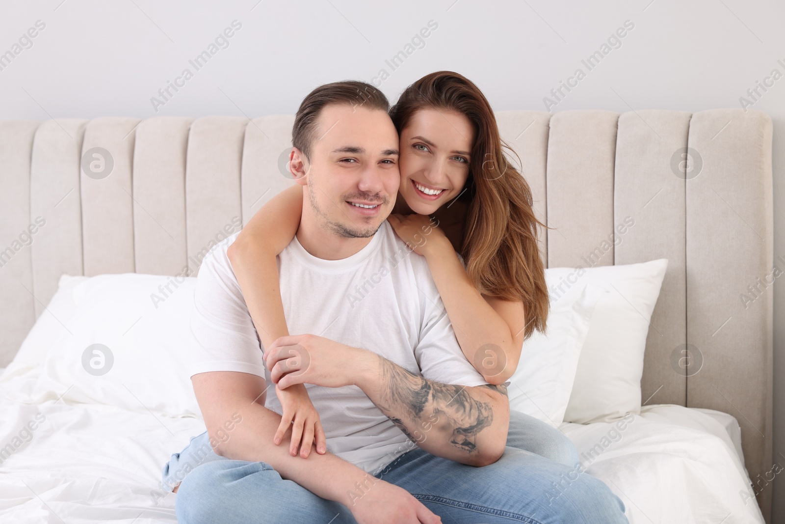 Photo of Happy couple spending time together on bed at home