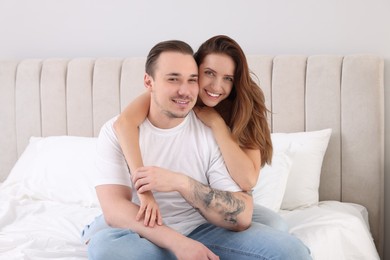 Happy couple spending time together on bed at home