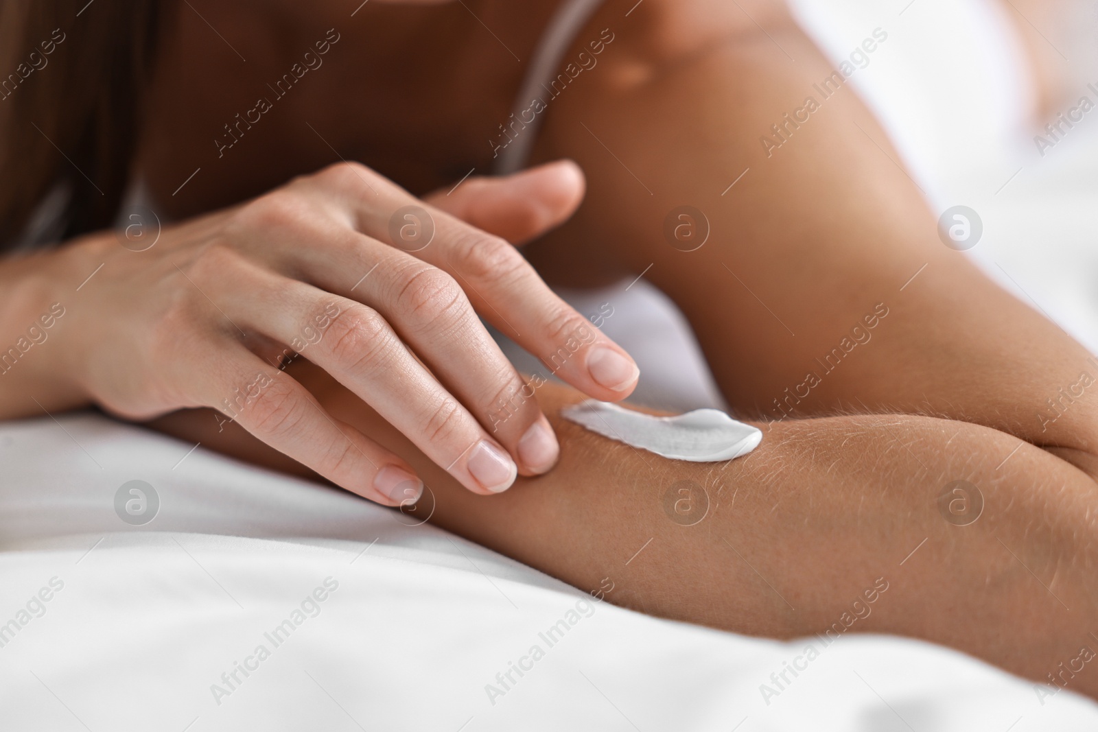 Photo of Woman with perfect skin applying cream onto hand, closeup. Body care