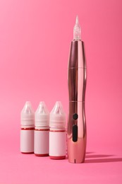 Permanent makeup machine and pigments on pink background