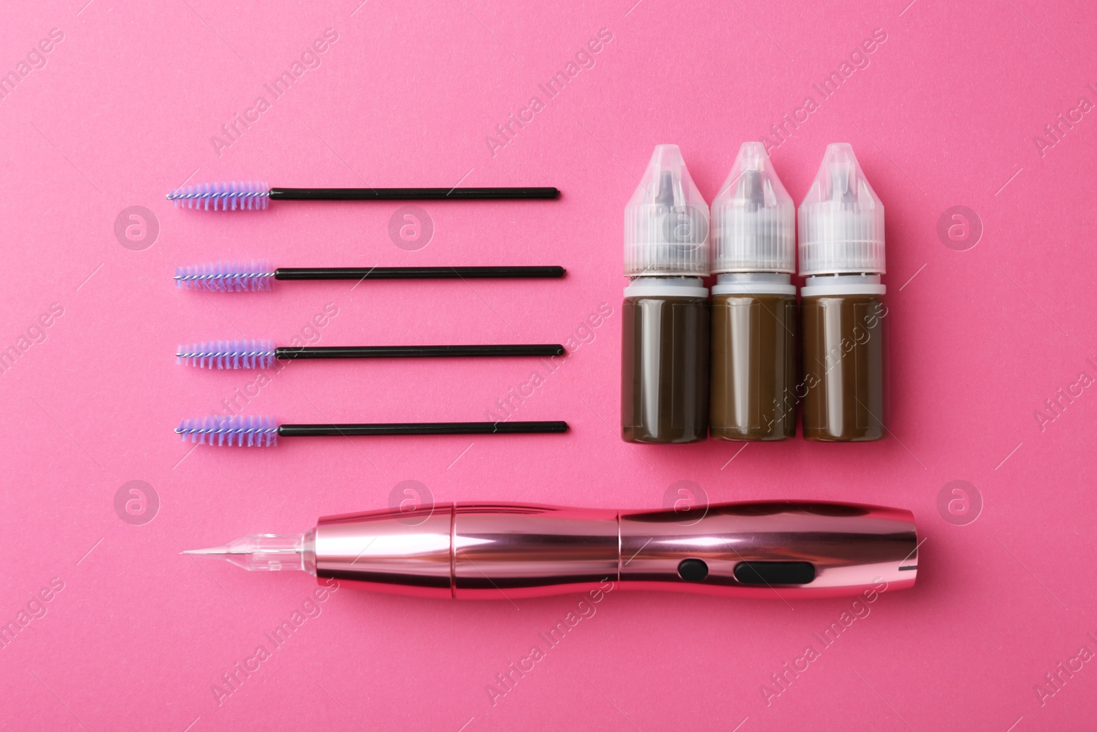 Photo of Permanent makeup equipment kit on pink background, flat lay