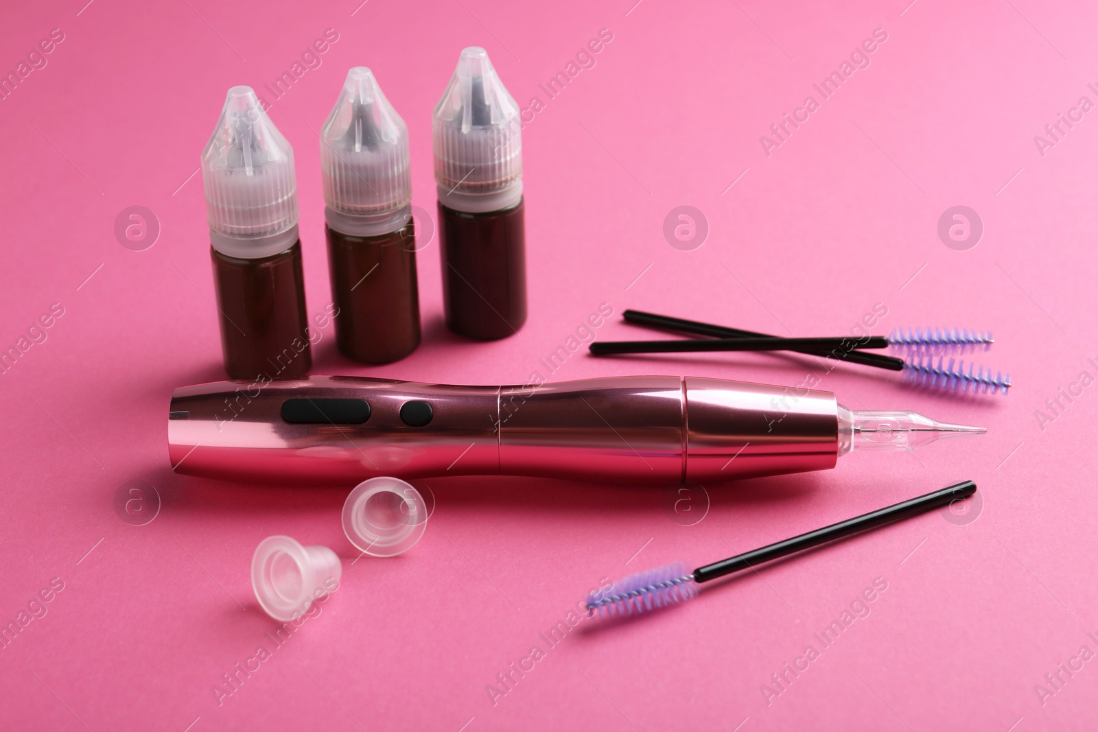 Photo of Permanent makeup equipment kit on pink background