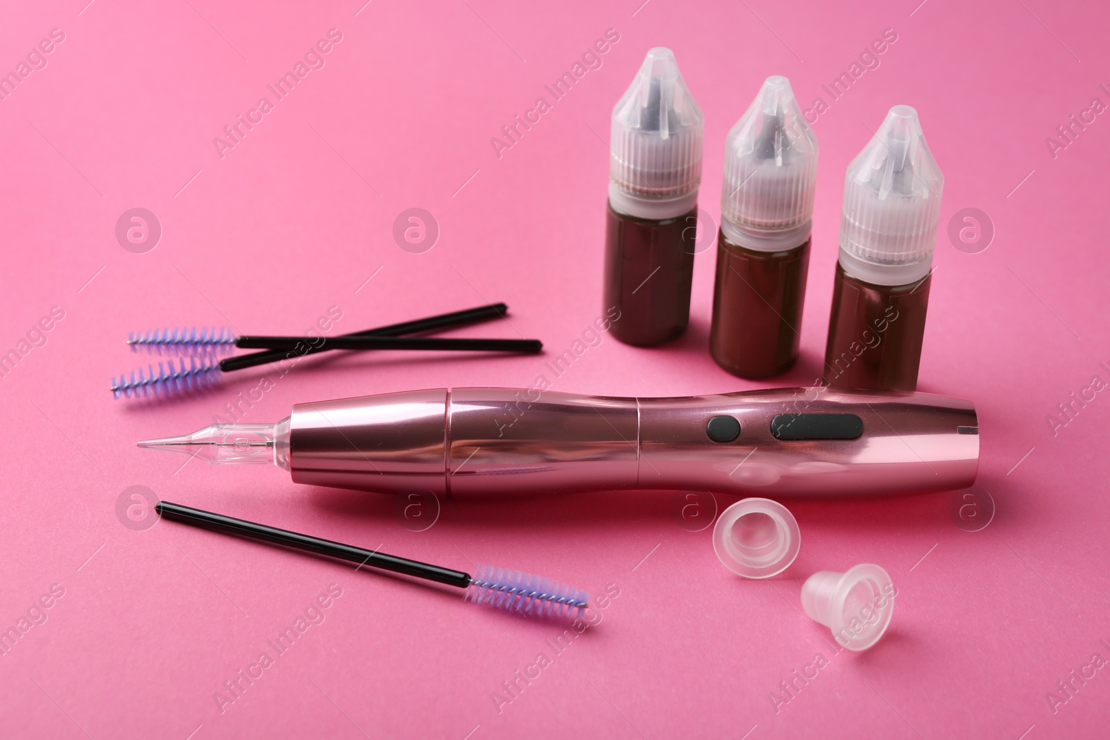 Photo of Permanent makeup equipment kit on pink background